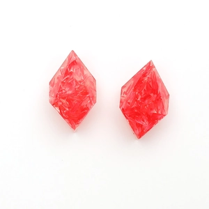 Detailed macro of diamond-shaped red resin earrings with delicate dried flower petals