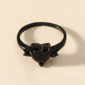 Black heart-shaped gemstone ring with blue side stones on a sleek black plated band