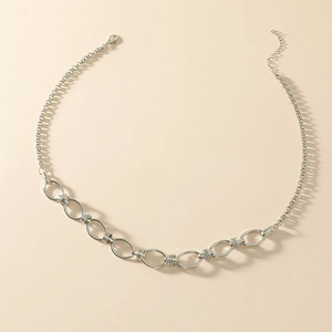 Collana minimalista color argento con maglie cave e chiusura a moschettone su sfondo beige