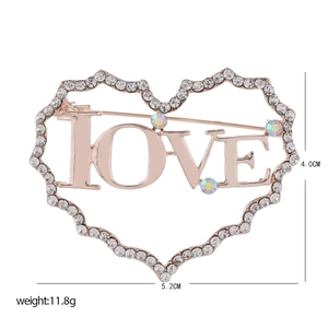 Détail macro de la broche cœur LOVE en or rose avec strass et cristaux scintillants