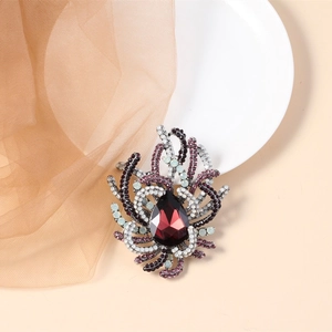 Close-up of vintage brooch with red teardrop crystal and colorful rhinestones on alloy