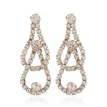 Close-up of golden tassel earrings with sparkling rhinestones and hollow circular details