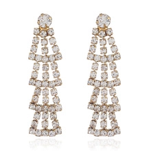 Close-up of long tassel earrings with sparkling rhinestones in a gold-plated setting