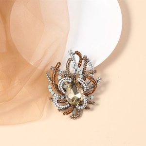 Detailed view of champagne teardrop crystal brooch with radiant amber rhinestones