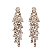 Detailed view of layered gold-tone fringe earrings with cascading round crystals