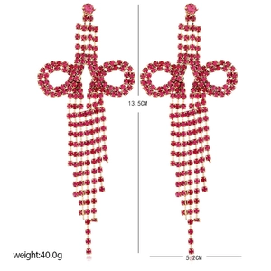 Detailed view of large fuchsia tassel earrings with crystal bows and dimension labels
