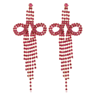 Macro shot of rose red rhinestone bow tassel earrings with sparkling gold metal chains