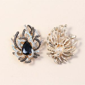 Detailed view of the front and back of a gold brooch with blue and black crystals