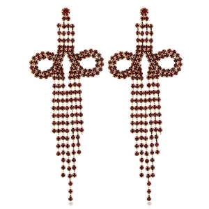 Detail of red rhinestone bow earrings with long gold tassel fringe for party