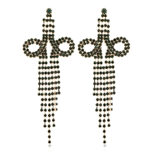 Detail of long tassel earrings with green rhinestones and golden bow-knot design