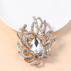 Detailed view of luxury gold brooch with water drop gem and blue crystal branches