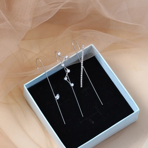 Three-piece silver ear cuff set with sparkling zircons on blue jewelry box