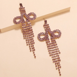 Detail of long gold tassel earrings with shimmering purple rhinestones for party wear
