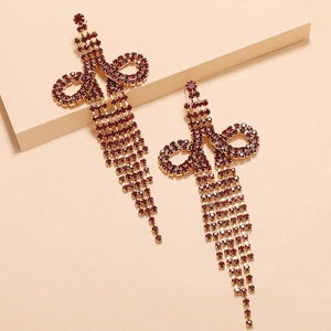 Detail of long drop tassel earrings featuring cascading rows of dark red rhinestones