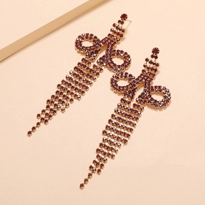 Detail of gothic sword earrings with deep red rhinestones and tiered long tassels
