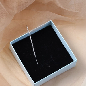 Silver long linear ear cuff with white pavé crystals inside a blue jewelry gift box