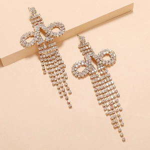 Macro shot of gold tassel earrings with glittering rhinestones on a warm background