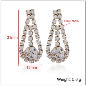 Detail view of 31mm long gold claw chain earrings with crystal tassels and 13mm width dimensions
