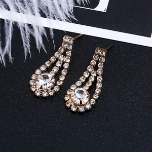 Detail of elegant gold drop earrings with sparkling round cubic zirconia inlay