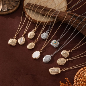 Collection of vintage gold and silver necklaces with engraved celestial pendants on velvet