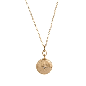 Close-up of golden compass locket necklace with tiny diamond and N E S W engraving