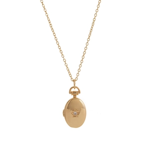 Close-up of golden oval locket necklace with engraved star and small diamond detail