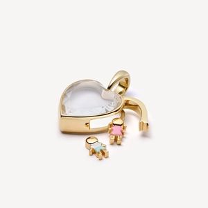 Macro detail of heart locket pendant with 18k gold plating and boy-girl charms