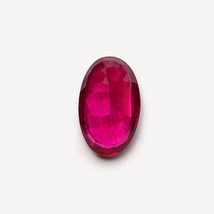 Macro detail of oval cut rose red gemstone with exquisite facets and high brilliance