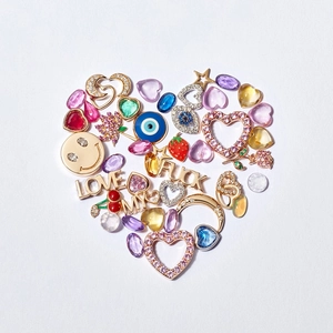 Collection of retro 18k gold plated charms arranged in a heart shape on white background