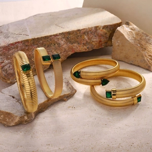 Close-up of 18K gold plated tubogas bracelets featuring emerald green zircon stones