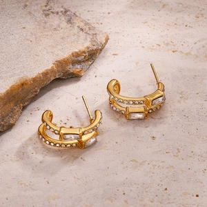 Élégantes boucles d'oreilles en C à double couche dorée avec zircons sur fond de pierre