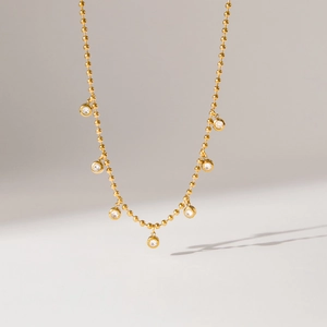 Dettaglio della collana a sfere dorate con sette pendenti in zircone scintillanti