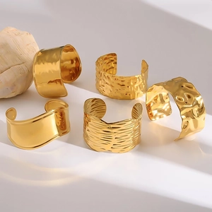 Coffret de 5 bracelets dorés texturés présentés sur des supports géométriques blancs