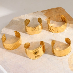 Détail du lot de 5 joncs dorés 18 carats avec textures martelées et ondulées sur pierre