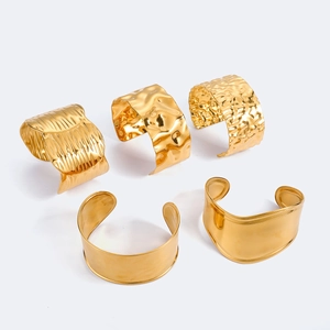 Détail de joncs en acier inoxydable plaqué or 18k aux textures martelées et ondulées