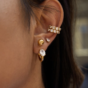 Golden stainless steel ear cuff set with cubic zirconia stones worn on ear