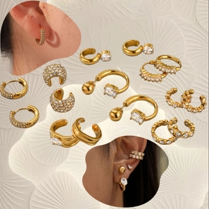 Elegant gold-tone ear cuff set with sparkling zircons on a textured background