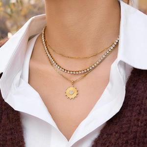 Set di tre collane dorate con catena tennis e ciondolo a cuore con sole su modella