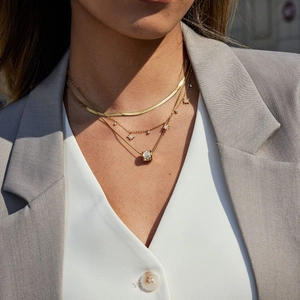 Elegante mehrlagige goldene Schlangenkette mit Sternanhängern und Pavé-Zylinder-Halskette