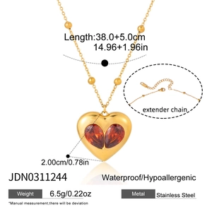 Collier cœur doré avec zircons rouges sur une chaîne à billes en acier inoxydable