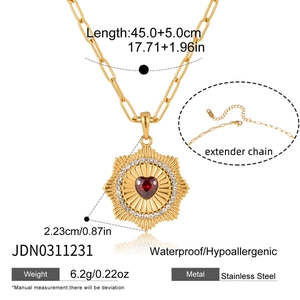 Collana a catena a graffetta dorata con gemma a cuore rosso e ciondolo a raggiera solare