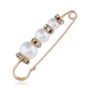 Elegante spilla a balia dorata con perle bianche e strass su sfondo bianco puro