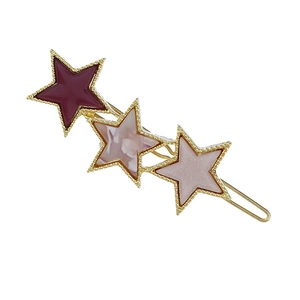 Close-up of star-shaped hair clip with marble resin texture and gold metal base