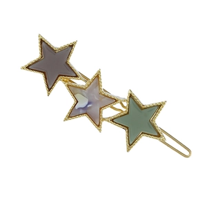 Detailed view of acetate star hair clip with gold metal frames and marbled texture