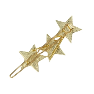 Detail view of the metal spring clip mechanism on gold star-shaped hairpins