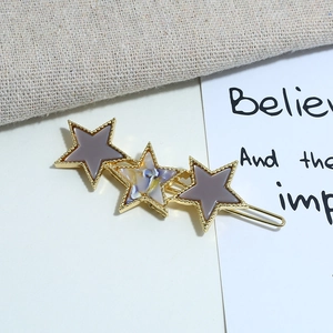 Star hair clip with three pentagrams on gold metal base featuring purple acrylic stars