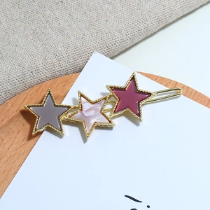 Detailed shot of star hair clips in colorful acetate finishes on a textured background