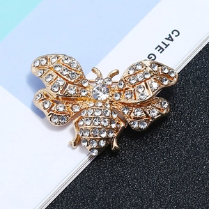 Detailed close-up of golden bee brooch with sparkling white rhinestones on wings
