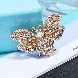 Close-up of golden butterfly brooch with sparkling crystals and hollow metal texture