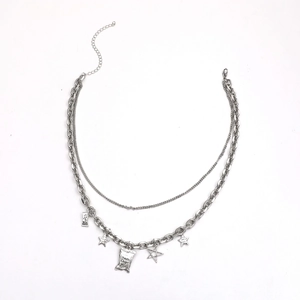 Détail du collier argenté double couche avec pendentifs étoile, chips et plaque steel